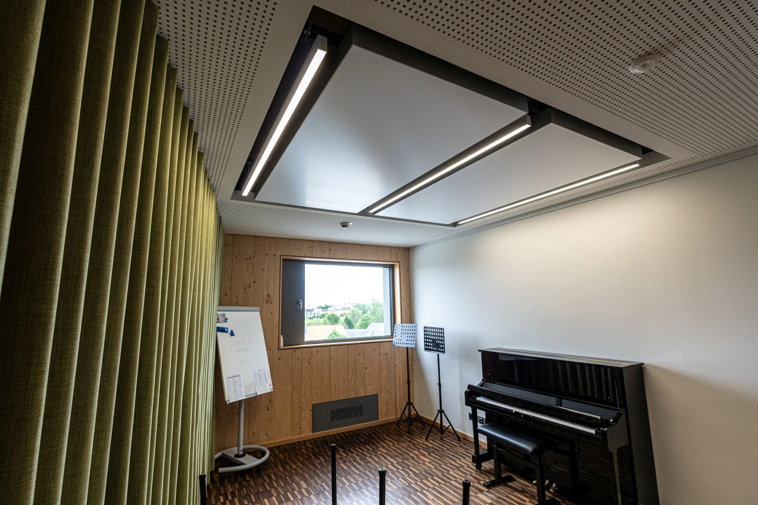 Unterrichtsraum der Musikschule Mamer mit interpanel Klimapanels unter der Akustikdecke, Klavier und Notenständern