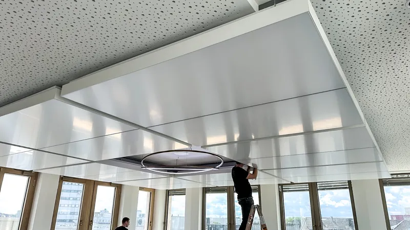 Montage der Deckensegel: Fachmonteur richtet die mittige ringförmige Akzentleuchte aus