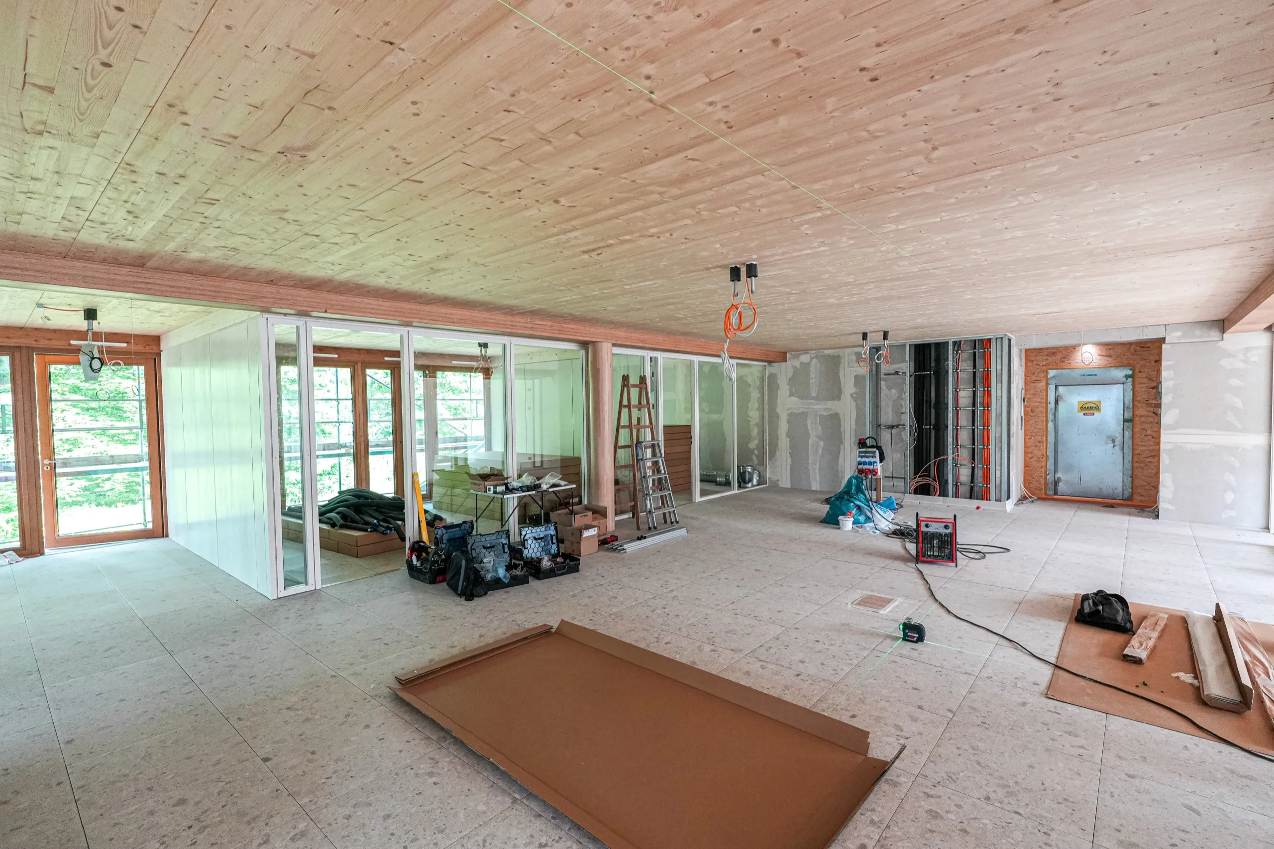 Baustelle im Holzbau mit angeliefertem interpanel Deckensegel und Werkzeug vor Montagebeginn