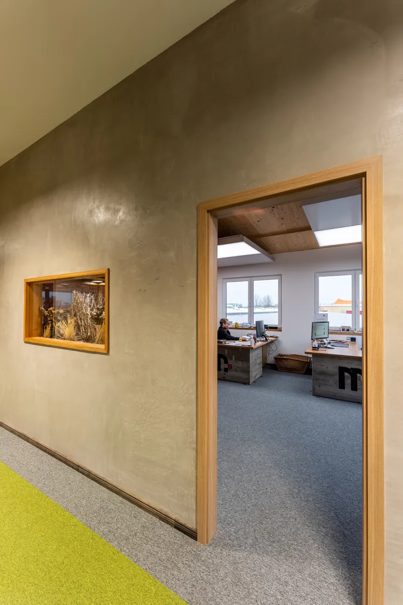Eingerichtetes Eckbüro mit Panoramafenster und interpanel Klimaleuchte unter der Sichtholzdecke