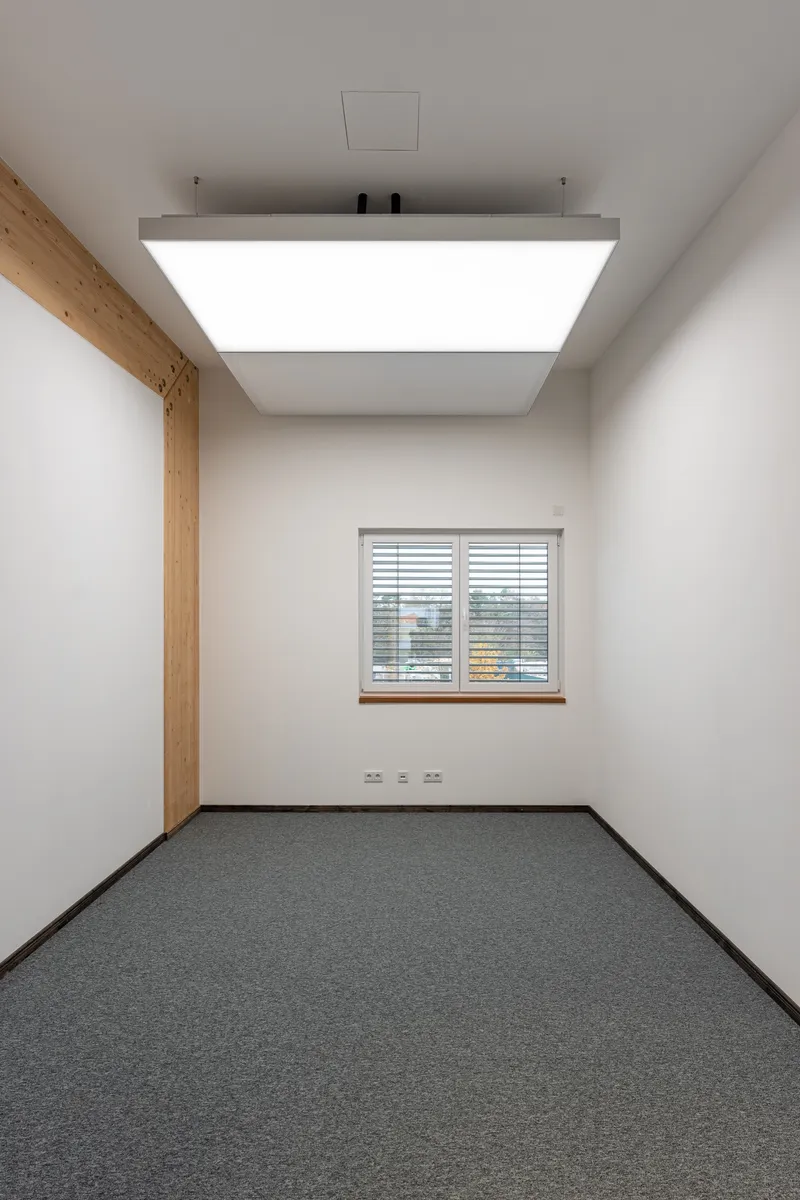 Büro mit Ziegelwand, Ledersofa und interpanel Klimaleuchten