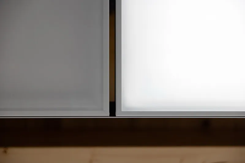 Untersicht: interpanel Klimaleuchte zwischen Holzbalken über dem Sprossenfenster