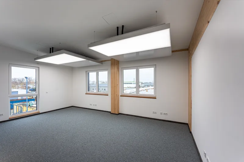 Büroraum mit interpanel Klimaleuchten zwischen Holzstützen