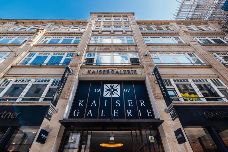 Außenansicht der denkmalgeschützten Fassade der Kaisergalerie Hamburg mit dem Schriftzug Kaisergalerie 1907 über dem Eingang.