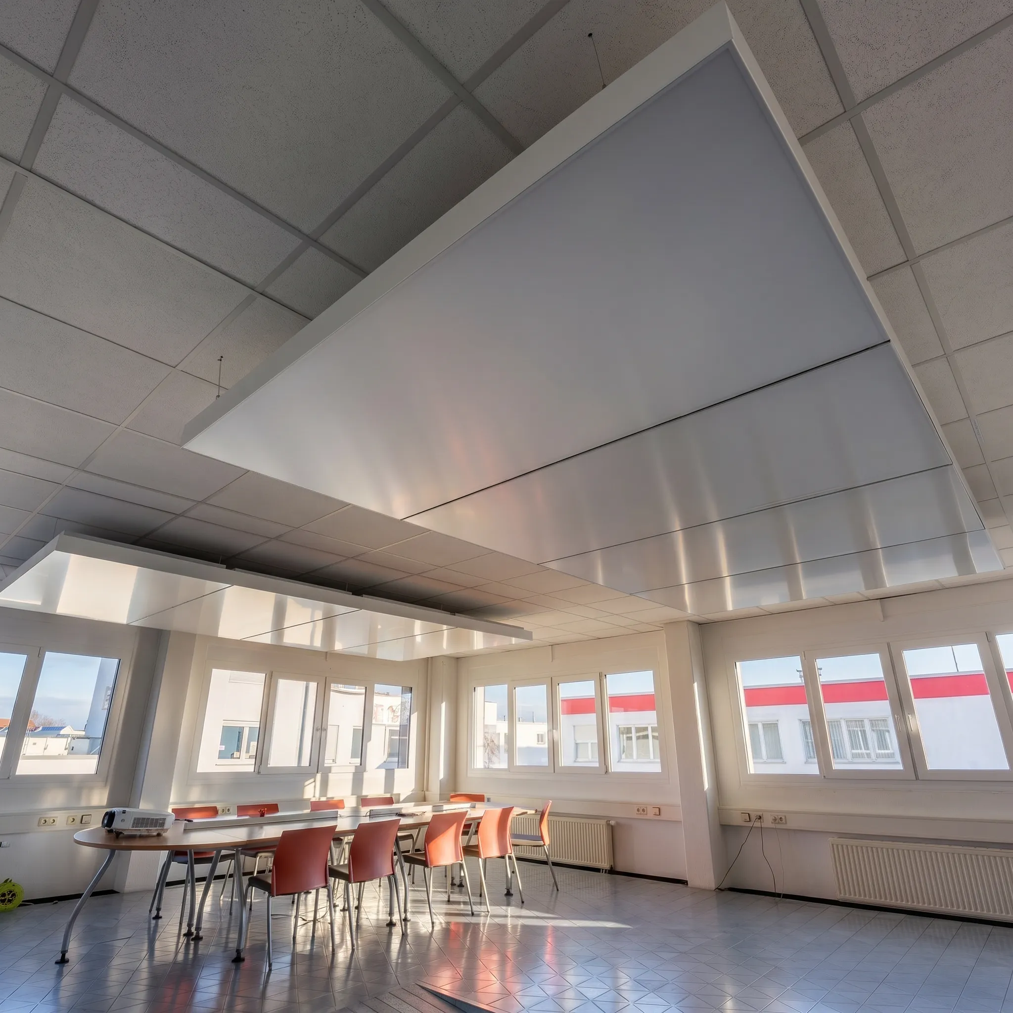 interpanel Klimapanel unter einer Rasterdecke in einem sanierten Büro mit Besprechungstisch