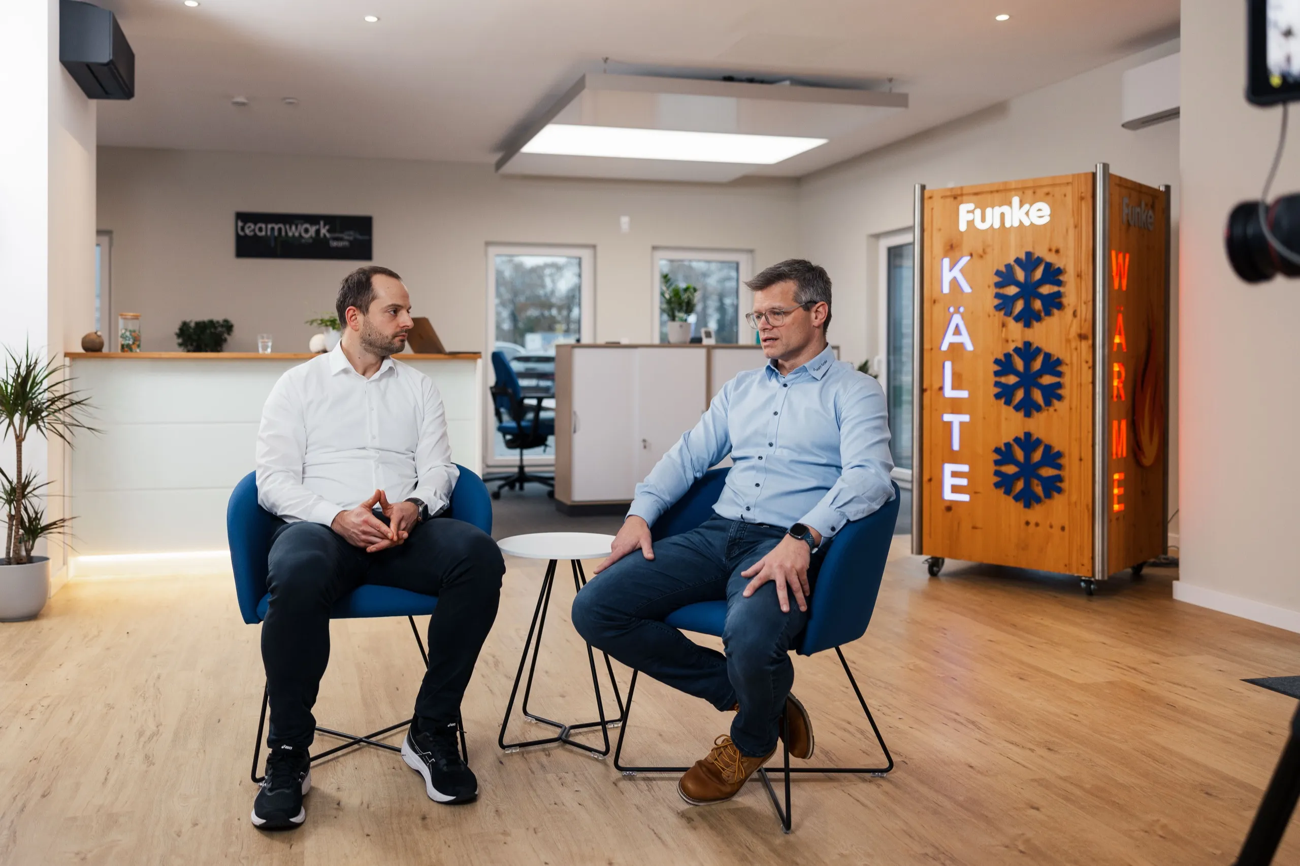 Torsten Lehmkuhl von Funke Klimatechnik und Alexander Buff von interpanel im Gespräch, im Hintergrund ein Funke Kälte-Wärme-Schauschrank