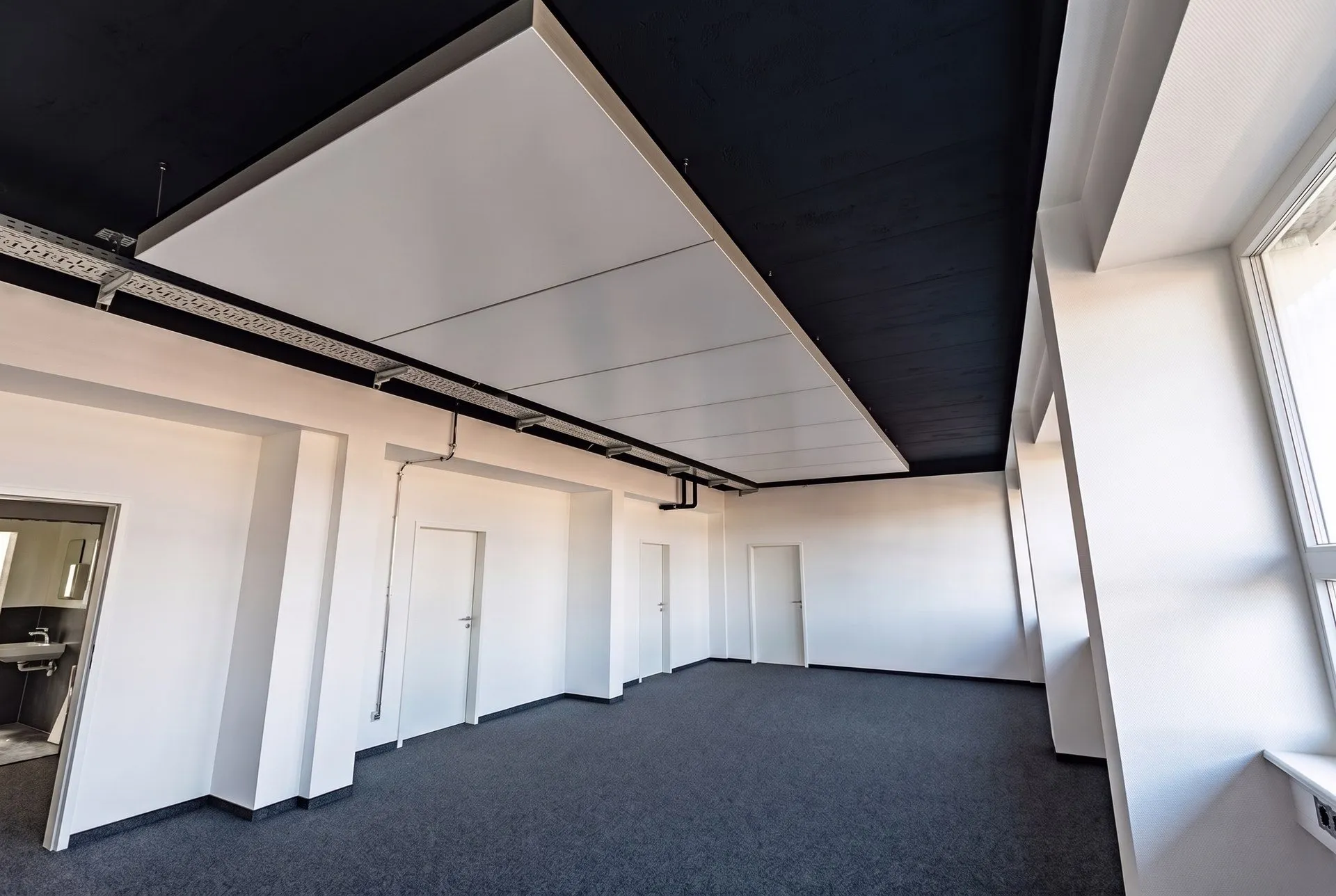 Büroraum im 4. Obergeschoss mit interpanel Deckensegel, Tür und Fensterfront