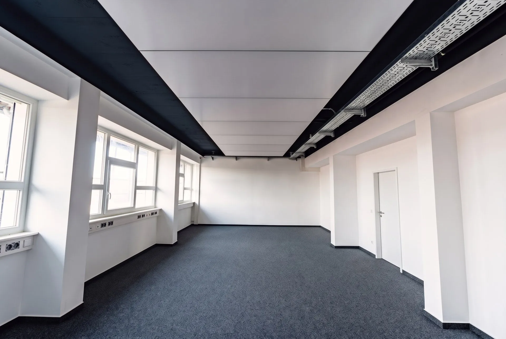 Langer Büroraum im 4. Obergeschoss mit interpanel Deckensegeln unter schwarzer Decke