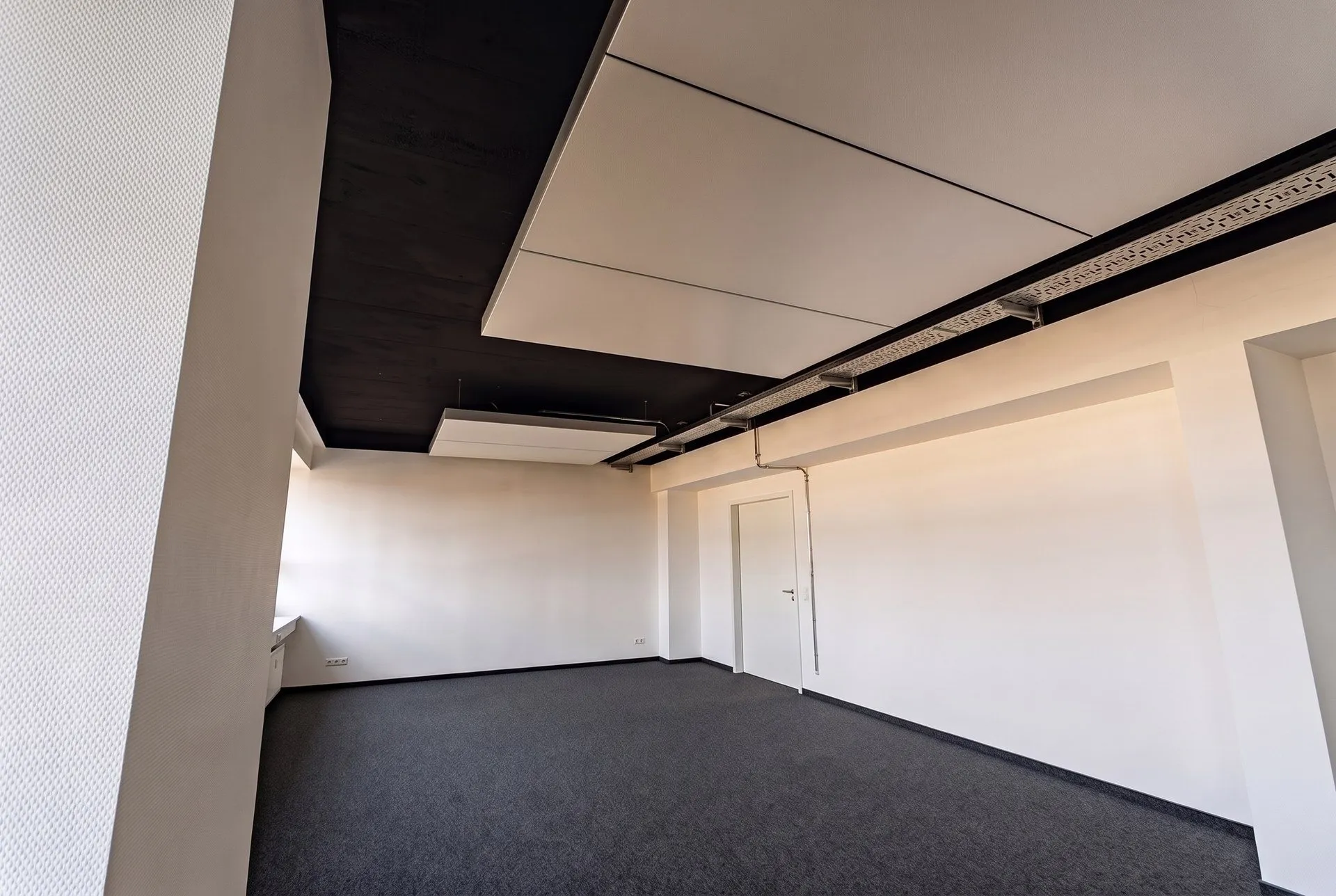 Büroraum im 4. Obergeschoss mit interpanel Deckensegel unter schwarzer Decke, Stütze und Fensterband